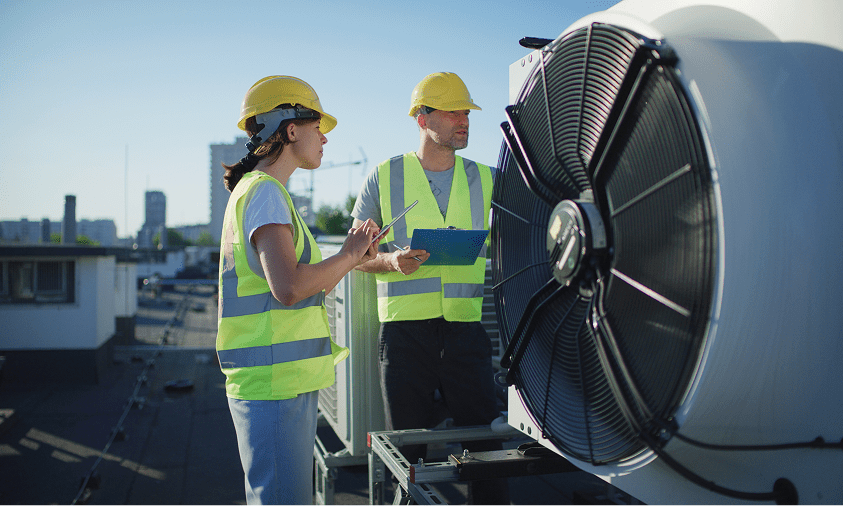 Workers inspecting rooftop HVAC system.