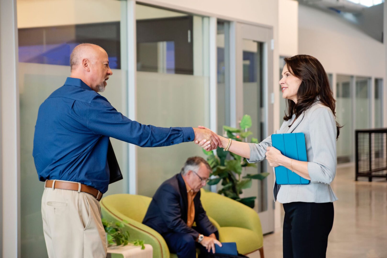 Man and woman shaking hands in office.